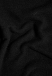 Tessuto nero con una texture liscia e opaca, caratterizzato da pieghe e rughe sottili. Colore uniforme senza motivi o accenti visibili.