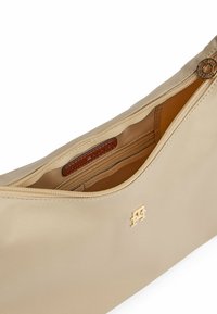 Beige synthetisch clutch met rits en goudkleurige details. Beschikt over een binnenvak en een leren label met merknaam. Gladde textuur en gestroomlijnd ontwerp.