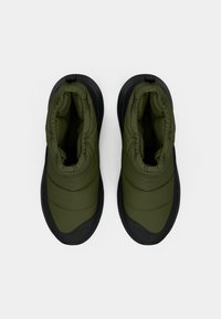 Zöld párnázott csizmák textúrált felsőrésszel és fekete gumi talppal. Érdekessége a ráncolt bokarész és a varrott részletek az anyagon.