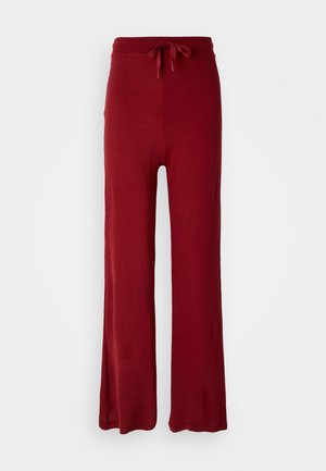 Pantaloni rossi a gamba larga realizzati in un tessuto morbido e con trama. Presentano una vita regolabile con un fiocco. Design dell'orlo piatto e uniforme.