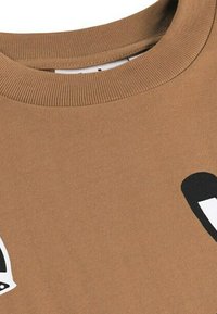 Sweat-shirt en coton marron avec un col côtelé et des éléments de design abstraits noirs sur le devant. Texture douce avec une coupe décontractée.