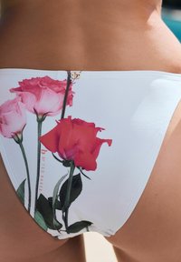 Costum de baie alb, cu un model floral de trandafiri roz și roșii, având un mic accent din metal aurit. Material neted și elastic.