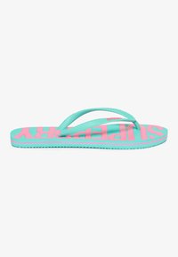 Aqua flip-flop med en tekstureret sål, brede pink bogstaver og fleksible stropper. Designet lægger vægt på komfort og afslappet stil.
