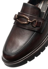 Mocassin en cuir brun foncé avec détail mors métallique et semelle extérieure en caoutchouc noir épaisse, montrant l'avant et la partie supérieure avant.