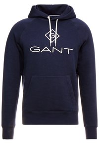 Felpa con cappuccio blu navy con tasca frontale, coulisse bianca e logo "GANT" ricamato. Presenta polsini e orlo a costine. Tessuto in misto cotone.