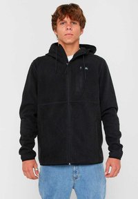 Sort fleece hættejakke med frontlynlås, justerbar hætte og sidelommer. Har tekstureret stof med kontrasterende strikpaneler i siderne.