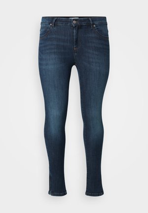 Jeans skinny in denim blu scuro, con un classico design a cinque tasche, chiusura frontale con bottone e dettagli leggermente rovinati all'orlo.