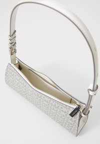 White handbag with a textured pattern featuring a silver zip closure, logo detail on the strap, and a smooth interior lining.