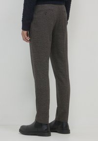 Braun karierte Hose aus strukturiertem Stoff, mit einem geraden Bein-Design und einer Gesäßtasche mit Knopfverschluss.