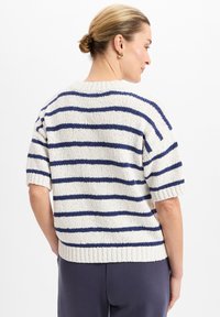 Korte-sleeve gebreide trui in het wit met marineblauwe strepen. Heeft een geribbelde zoom en een ontspannen pasvorm. Textuurstof voegt diepte toe aan het ontwerp.