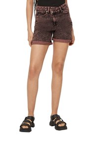 Szorty dżinsowe w bladoskamiennej kolorze burgundowym, z podwiniętymi mankietami, pięcioma kieszeniami i metalowym guzikiem. Noszone z masywnymi czarnymi sandałami.