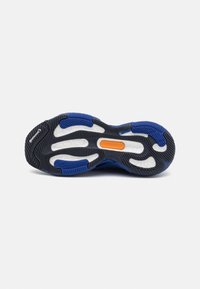 Schoenenzool met een blauw en zwart rubberen ontwerp, voorzien van geprofileerde antislipgroeven en een centrale witte dempingsinvoeg; opvallende oranje accent.