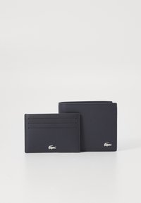 Set de portofel din piele navy și suport pentru carduri cu logo argintiu. Portofelul are mai multe sloturi pentru carduri și o deschidere verticală. Textură netedă.