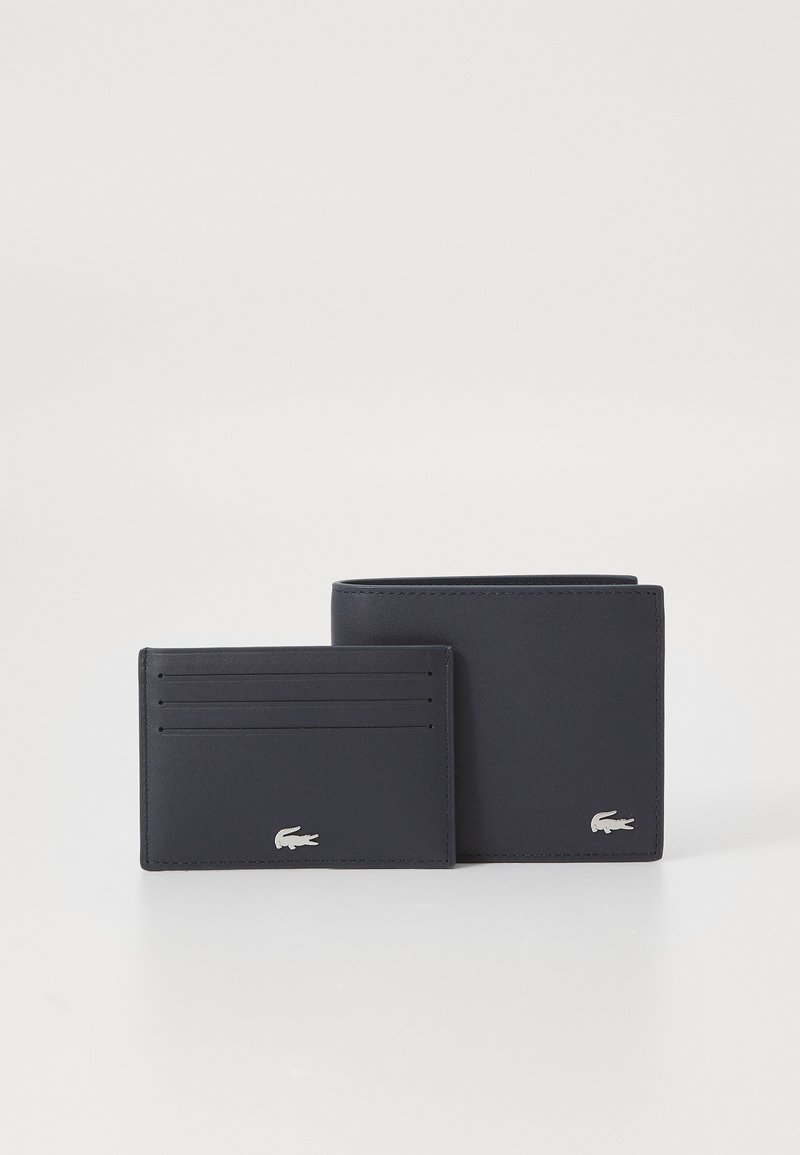Set de portofel din piele navy și suport pentru carduri cu logo argintiu. Portofelul are mai multe sloturi pentru carduri și o deschidere verticală. Textură netedă.