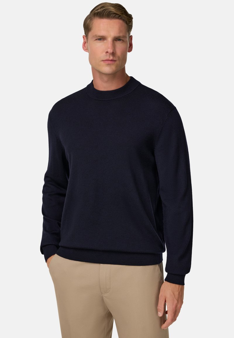 Dark navy knit sweater with a round neck, long sleeves, and ribbed cuffs. Smooth texture, fitted design, and casual silhouette.