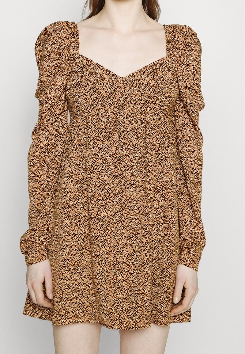 Robe marron à motifs avec manches ballon, encolure carrée, coupe décontractée et texture douce. Le tissu présente un petit motif animalier foncé.