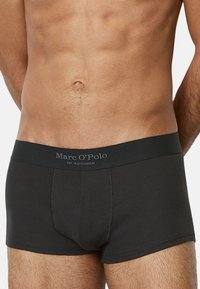 Schwarze Ripp-Boxershorts mit einem weichen Bund, der mit "Marc O'Polo"-Branding versehen ist, designed für Komfort und Passform.