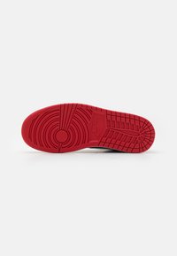 Soletta di sneaker Nike con un design in gomma rossa testurizzata, caratterizzata da motivi circolari e a spina di pesce per garantire trazione.