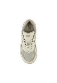 Scarpa sportiva beige chiaro realizzata in materiali mesh e sintetici, con punta rotonda, chiusura con lacci e dettaglio del logo sulla linguetta.