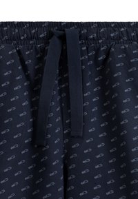 Granatowe szorty z tkaniny z elastycznym pasem i sznurkiem do regulacji. Posiadają mały, powtarzający się wzór w jasnoniebieskim kolorze. Miękka tekstura, luźny fason.