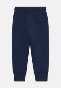 Pantaloni sportivi per bambini di colore blu navy con elastico in vita e polsini a coste, posati su uno sfondo bianco.