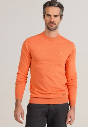 Orange knitted sweater with a round neckline, ribbed cuffs, and hem. Features a small logo patch on the left chest. Smooth texture.