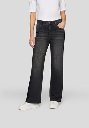 Black wide-leg jeans in denim, featuring front pockets and a button closure. Paired with a white short-sleeve top and white sneakers.