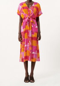 Un vestito lungo fino al ginocchio, con bottoni e un vivace motivo geometrico nei colori rosa, arancione e giallo, caratterizzato da maniche corte e una vita legata.