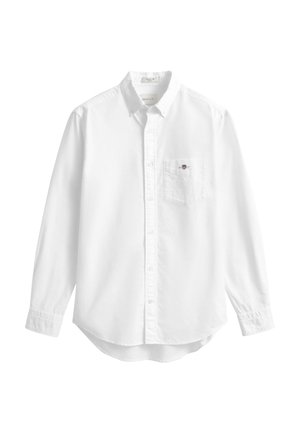 Camisa blanca de manga larga fabricada en algodón. Cuenta con un cuello abotonado, un bolsillo en el pecho izquierdo y un dobladillo curvado. Textura suave.