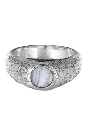 Sølv ring med tekstur, der har en cirkulær, gennemsigtig agatsten indlagt. Ringen har et råt overfladedesign med naturlige mønstre.