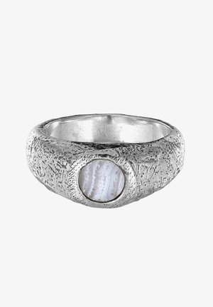 Sølv ring med tekstur, der har en cirkulær, gennemsigtig agatsten indlagt. Ringen har et råt overfladedesign med naturlige mønstre.
