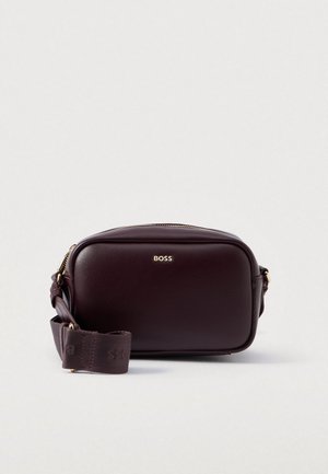 Bolso de hombro de piel burdeos con forma rectangular, herrajes dorados y una correa de tela desmontable con un logo. Cierre de cremallera.