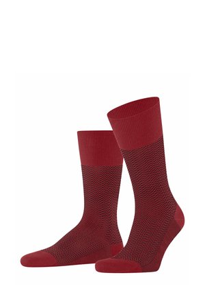 Red socks featuring a herringbone pattern in black, ribbed cuffs, and a reinforced toe. Made from a stretchy fabric for comfort.