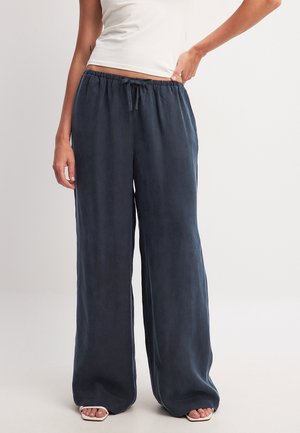Wide-leg, dark navy trousers in a smooth, lightweight fabric with an elastic waistband and drawstring detail. No visible patterns or accents.