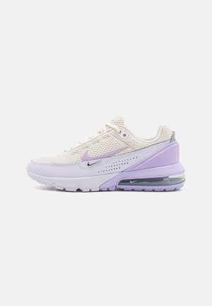 Baskets Nike avec une tige en mesh et synthétique en crème et violet clair. Caractéristiques d'une unité air visible, d'une semelle texturée et d'accents argentés.
