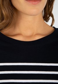 Sort T-shirt med vandrette hvide striber. Rund halsudskæring, blødt stof, glat tekstur og korte ærmer.