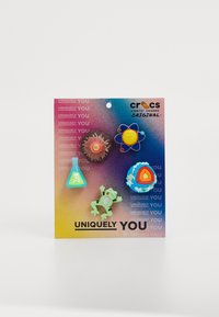 Öt darabból álló Crocs Jibbitz charm készlet egy színátmenetes háttéren. Tartalmaz egy tudományos kémcsövet, atomot, vulkánt, globust és békát, élénk színekben.