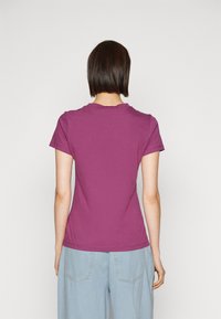 Fialové tričko s krátkým rukávem, kulatým výstřihem, hladkým bavlněným povrchem a přiléhavým střihem. Zadní pohled ukazuje čisté detaily šití.