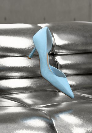 Svetlo modra čeveljka z visoko peto, z ostrim sprednjim delom in odprtim zadnjim delom. Iz materiala, ki spominja na semiš, z vitko peto in gladkim podplatom.