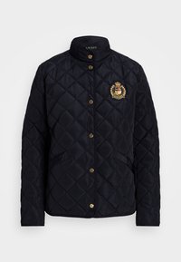 Tmavě modrá prošívaná bunda s límcem do stoje, zlatým kováním a vyšívaným emblémem na hrudi. Navržena s předními kapsami.