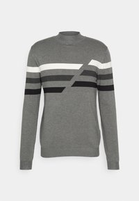 Suéter gris con mangas largas, cuello alto y rayas geométricas en negro, blanco y diferentes tonalidades de gris a lo largo del pecho.