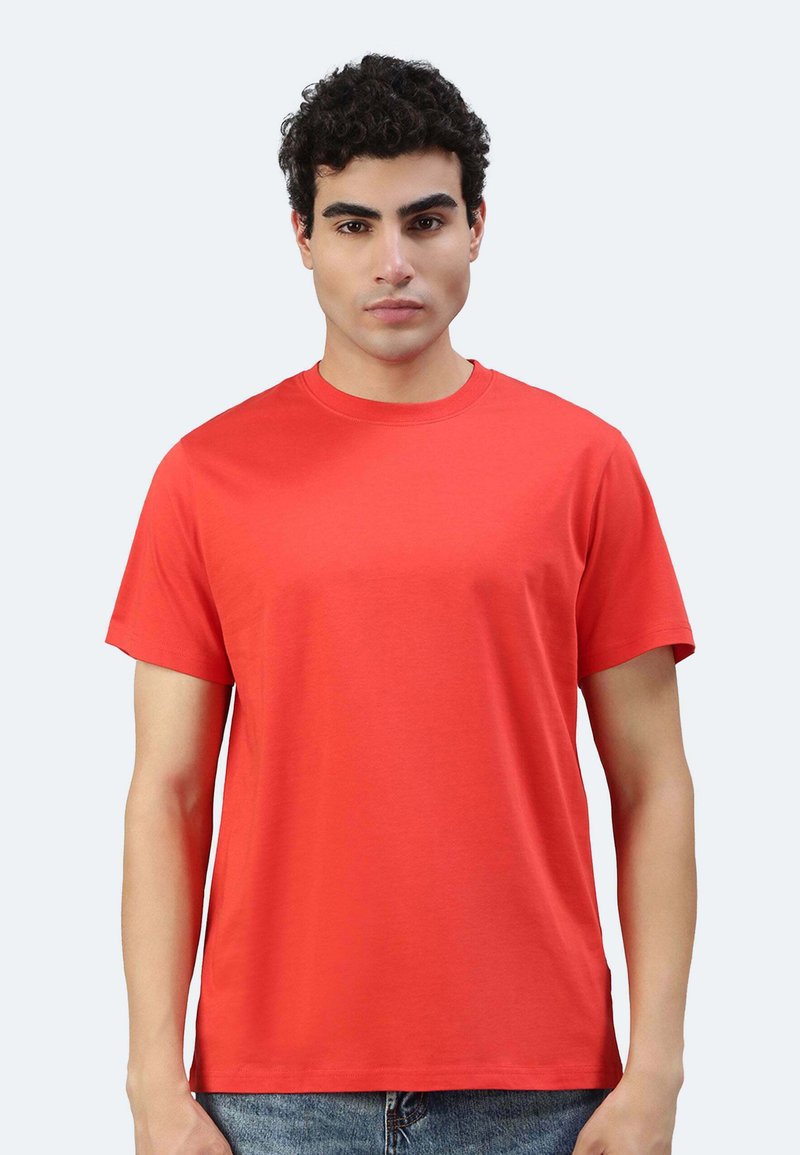 T-shirt en coton rouge avec un col rond et des manches courtes. Design simple, coupe droite, sans motifs ni embellissements.