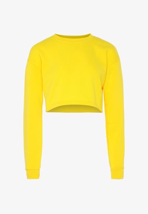 Felpa gialla brillante a maniche lunghe e cropped, con colletto e polsini a costine, esposta piatta su uno sfondo bianco.