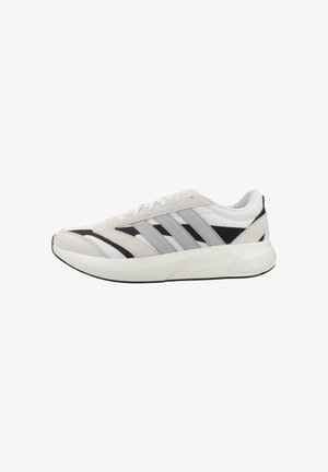 Zapatilla deportiva baja en blanco y negro con rayas grises, cierre de cordones, cuello acolchado y suela blanca gruesa y acolchada.