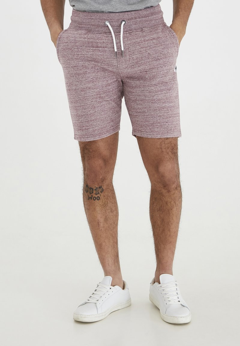Burgundy stickade shorts med elastisk midja och dragsko. Funkar sidofickor och en logodetalj nära fållen.