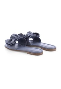 Paarse rubberen schuifsandalen hebben een grote strikaccent, open ontwerp, platte zool en een getextureerde voetbed voor comfort.