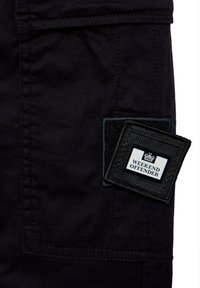 Sort stof cargo shorts med et vævet mærke med "WEEKEND OFFENDER" på en firkantet baggrund, strukturerede kanter og pæne syninger.