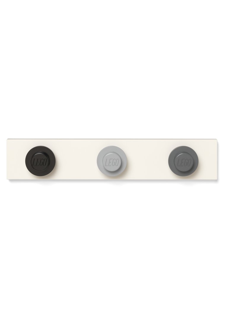 LEGO wandbevestigingsclip in beige met drie ronde knoppen: zwart, lichtgrijs en donkergrijs, elk met het reliëf van het "LEGO"-logo.