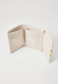 Beige skinnlommebok med flere kortspor, gullfargede detaljer, glatt tekstur og en glidelåslomme for mynter.