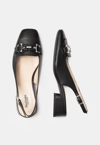 Zapatos de cuero negro tipo slingback con punta cuadrada, que presentan una hebilla decorativa y un tacón bajo. Textura suave con un interior beige.
